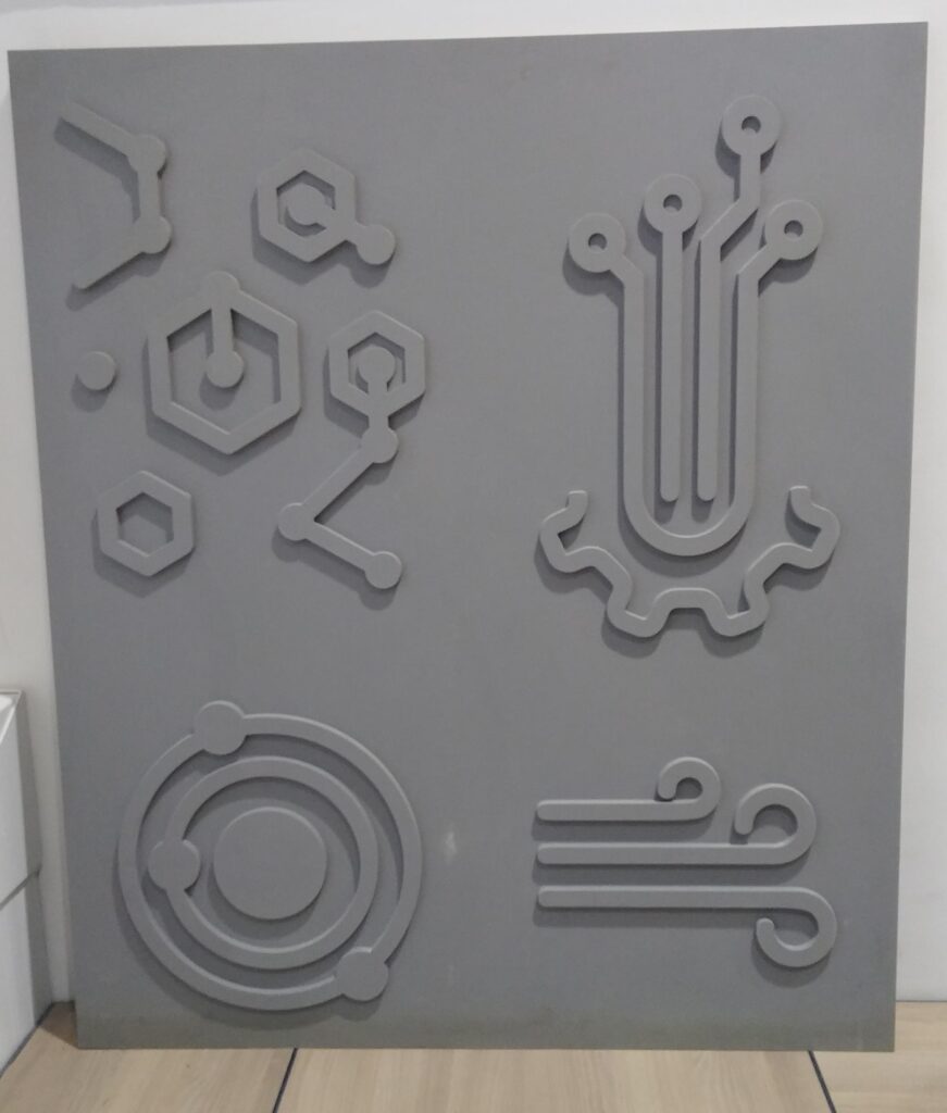 Présentation d'une plaque grise avec les motifs en reliefs qui ont servis à faire les empruntes dans le béton des façades.